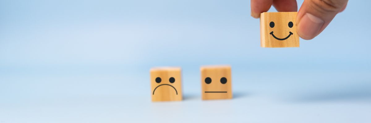 Dobbelstenen met blij en somber gezicht